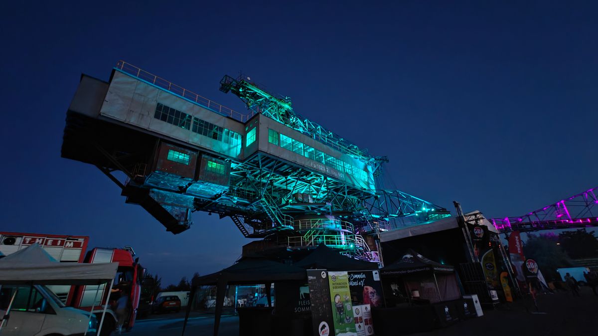 Festival-Gelände bei Nacht – grüne und blaue Lichter