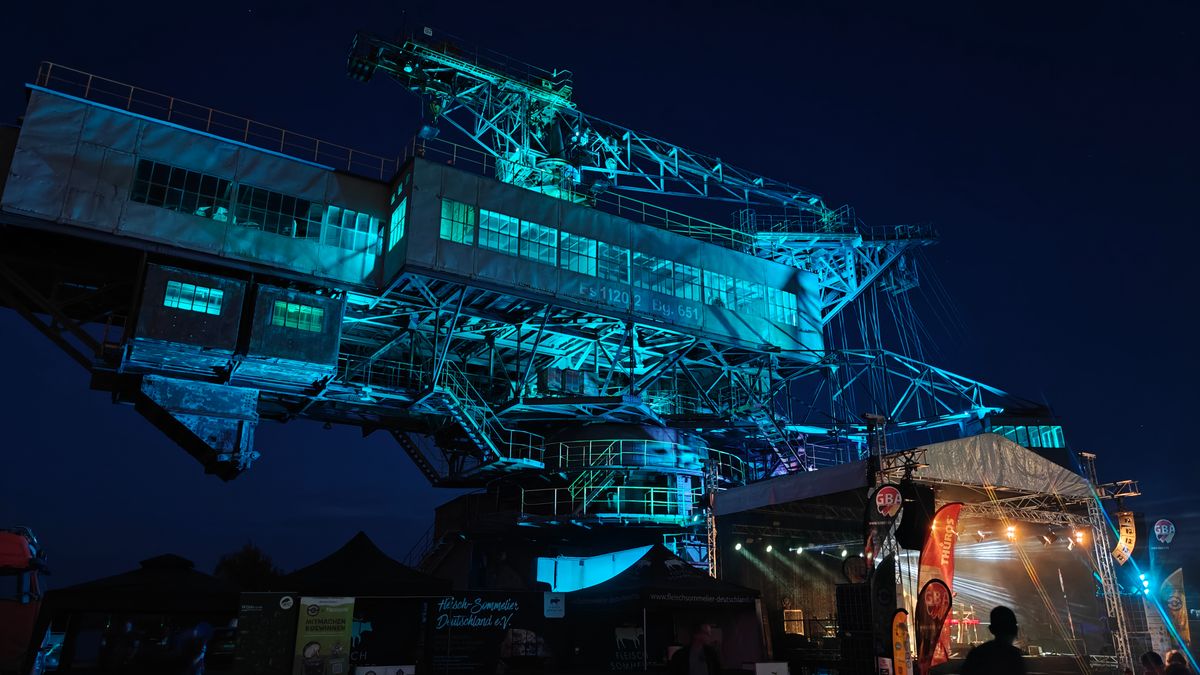 Festival-Gelände bei Nacht mit blauer Beleuchtung