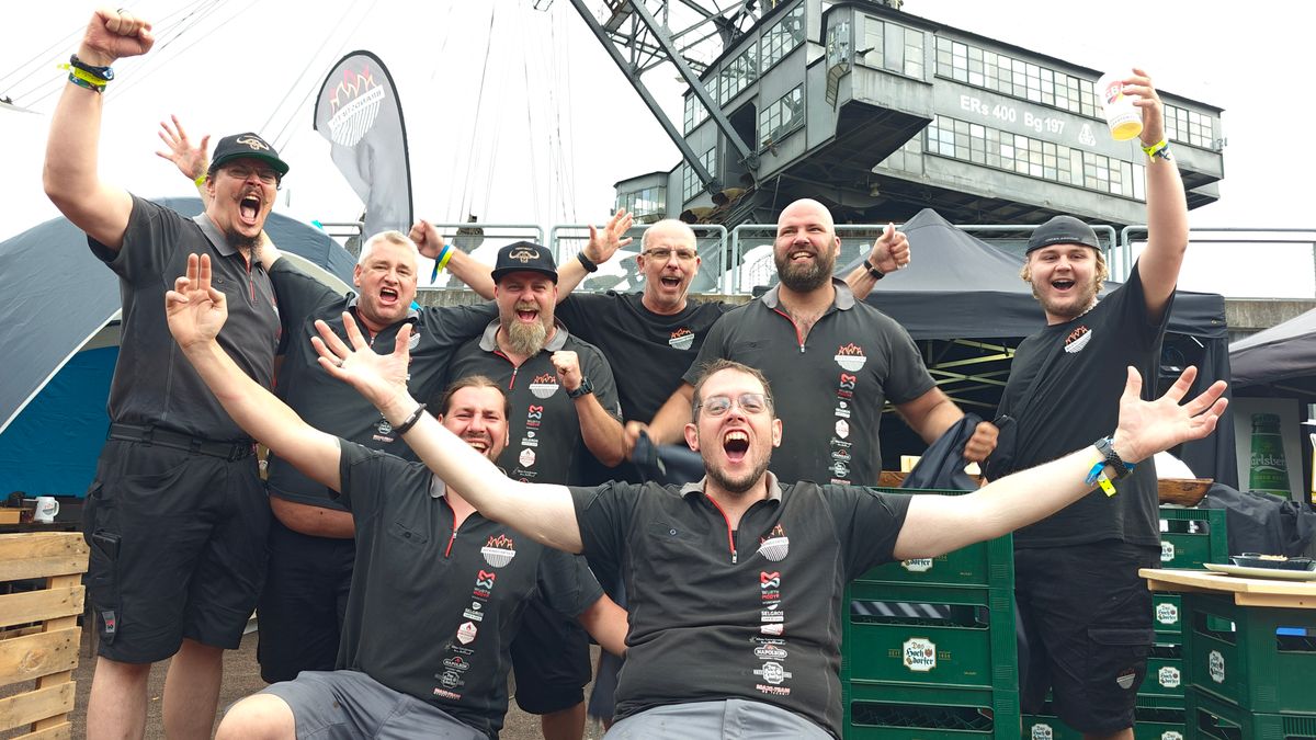 BBQ-Team feiert ausgelassen den Sieg vor dem Bagger