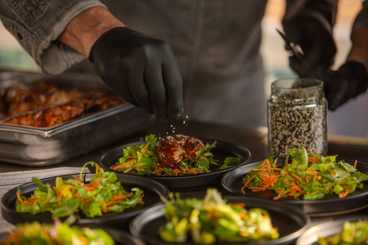 Sesam wird über angerichtete Teller gestreut