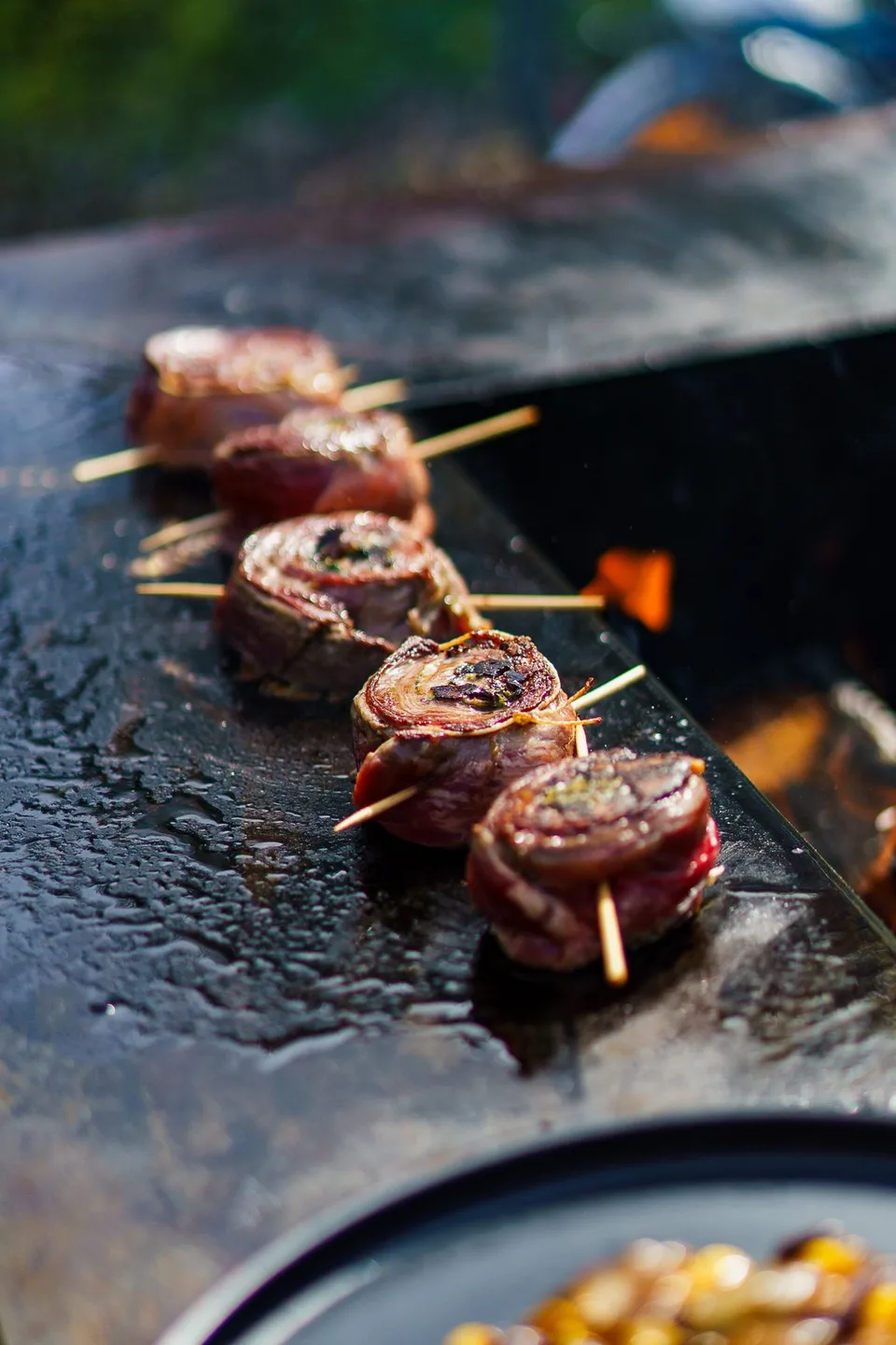 Gerollte Fleischstücke auf Spießen braten auf der Grillplatte